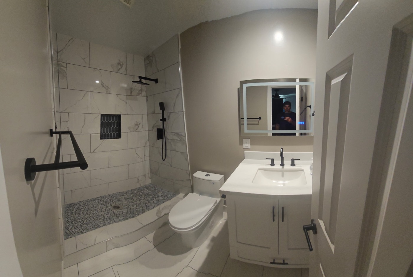 Custom marble walk-in shower with white vanity