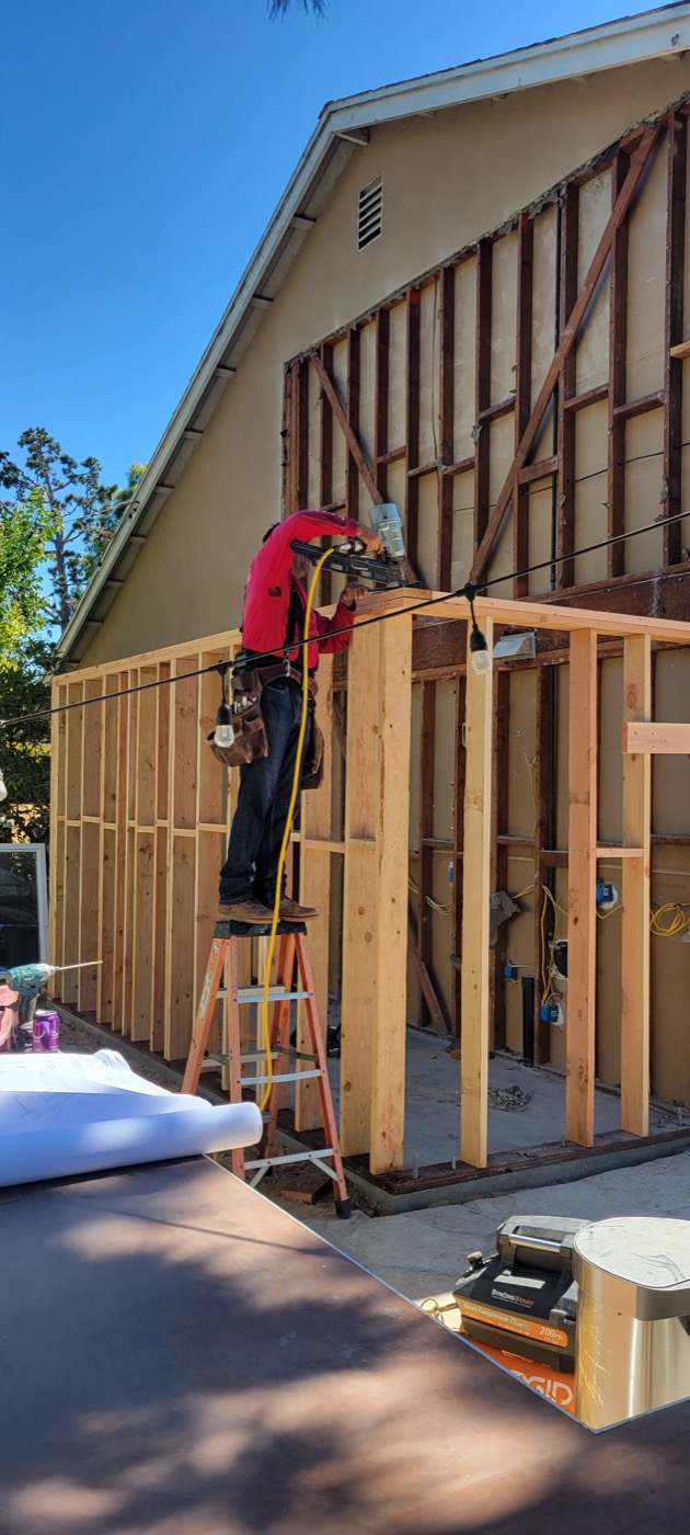 Carpenter framing a home addition wall
