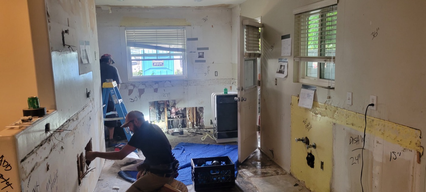 Kitchen stripped to studs with crew planning remodel layout