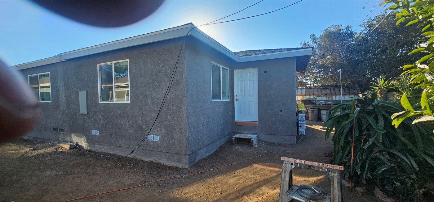 Completed ADU with grey stucco exterior and landscaping