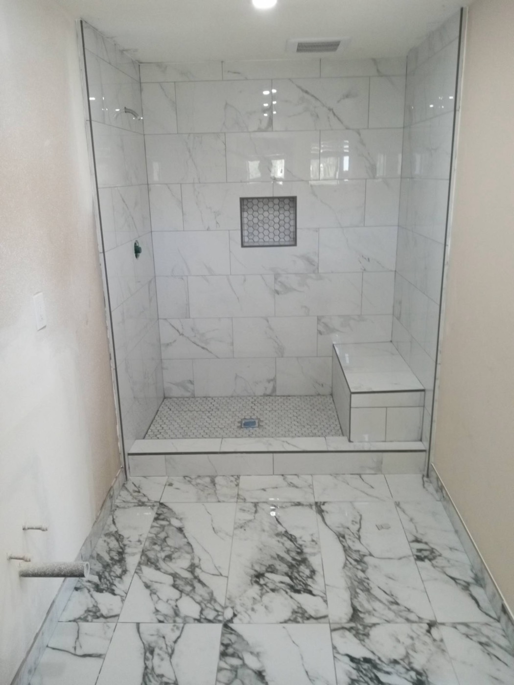 Oversized marble shower with built-in bench