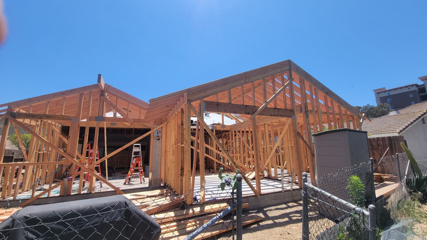 Large custom home full wood frame under bright sky