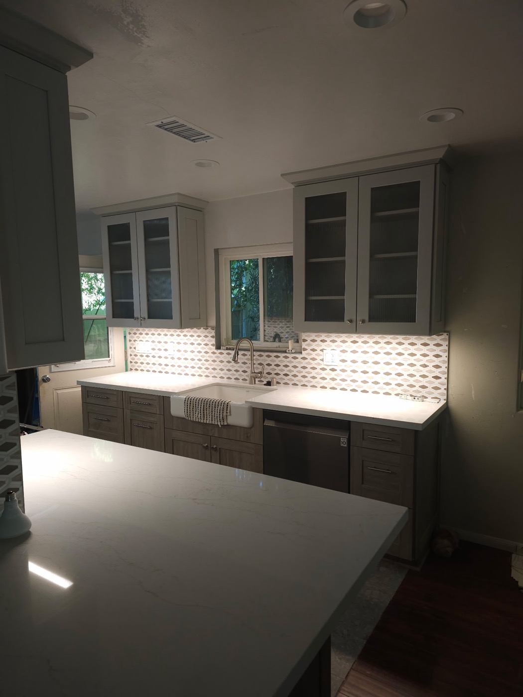 Completed kitchen remodel with farmhouse sink and quartz countertops