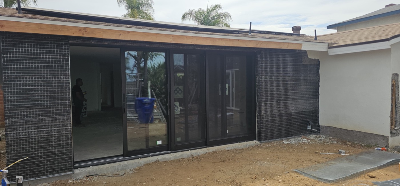 Home addition with large sliding glass doors and modern exterior