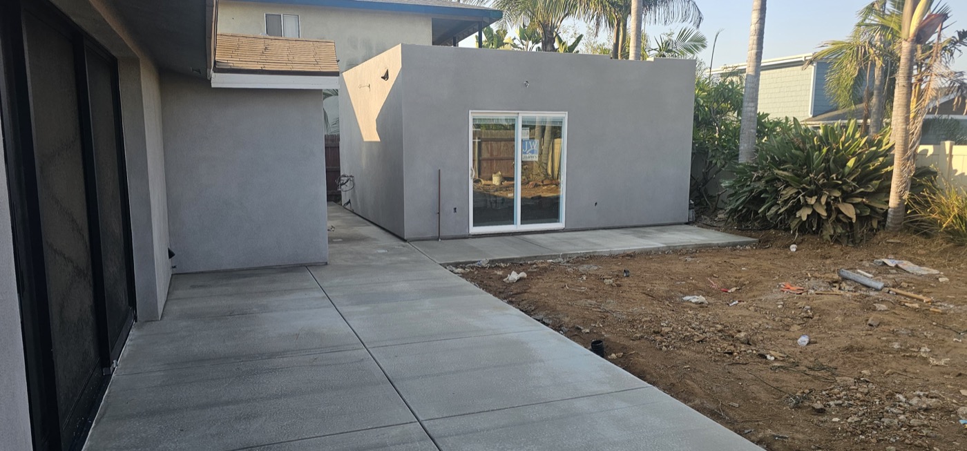 Completed ADU with grey stucco finish and concrete pathway