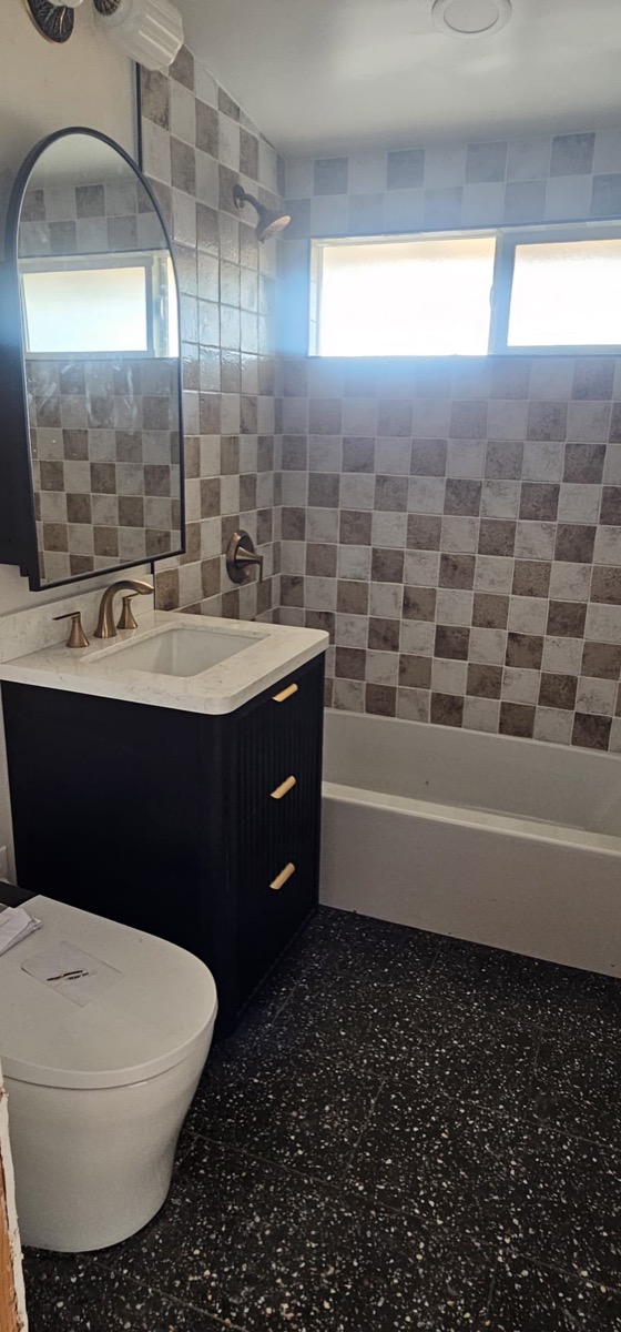 Bathroom remodel with checkered wall tile and terrazzo floor