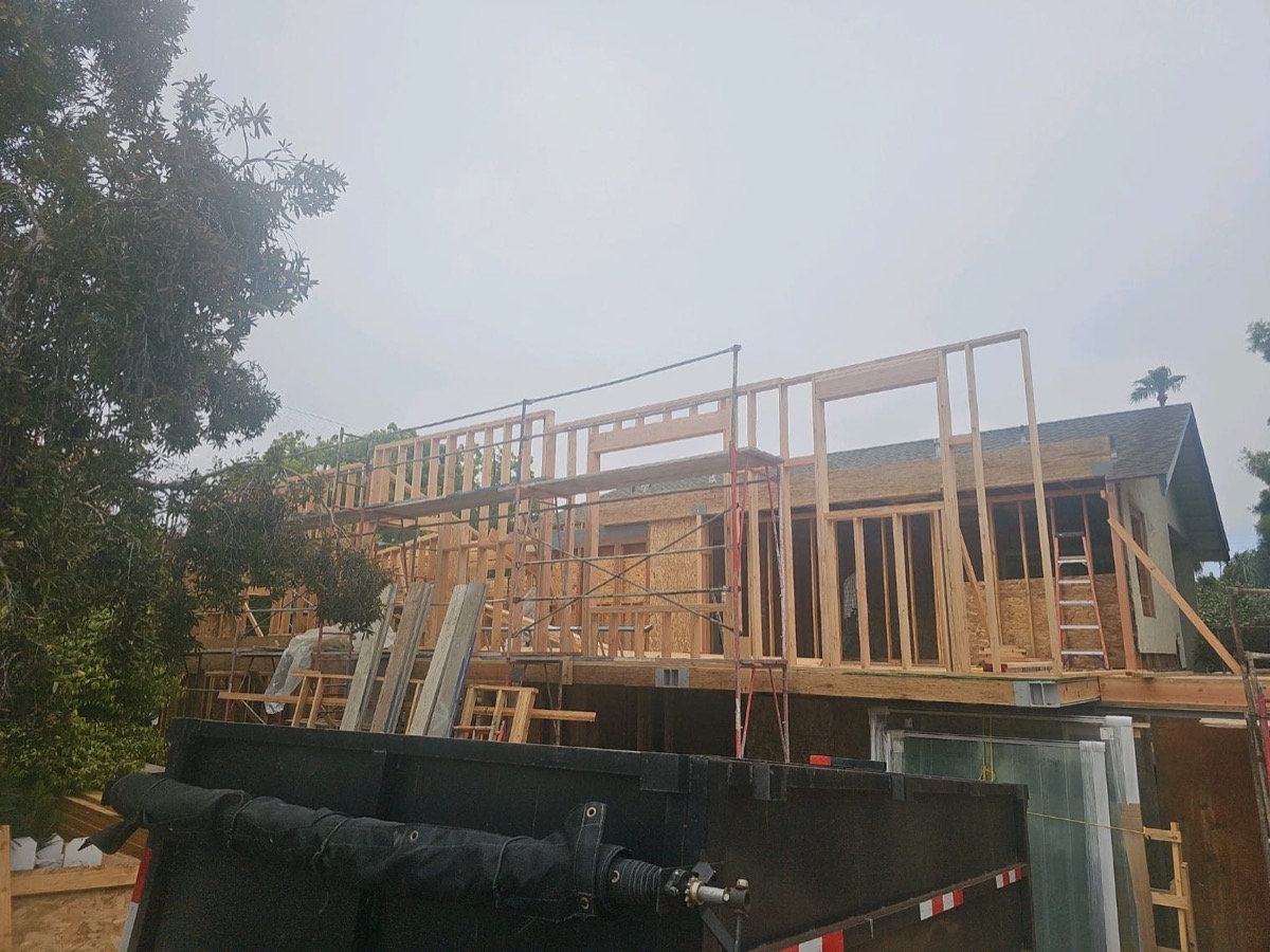 Large two-story home framing under overcast sky